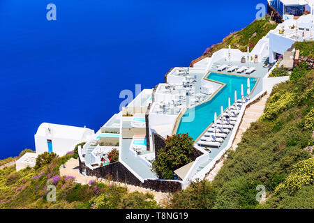 Santorini, Greece white houses architecture, hotels with caldera blue sea view and flowers blossom in famous island Stock Photo