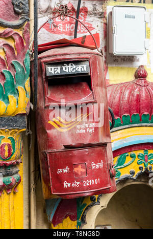 Old red post box on colourful wall of a Hindu temple in the Old City of Varanasi, India Stock Photo