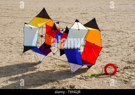 Ouddorp, The Netherlands, October 6, 2018: Multi-colored kite with a complex frame based on hexagons on a sandy surface Stock Photo
