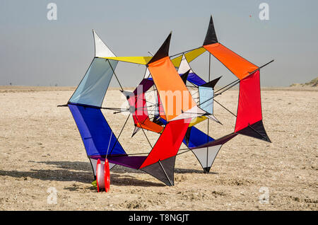 Ouddorp, The Netherlands, October 6, 2018: hexagonally shaped kite with various vibrant colors on the beach with sea and dunes in the background Stock Photo