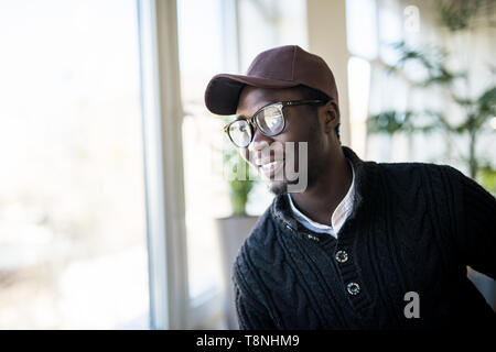 Portrait of pensive african american businessman standing near window and thinking about decision, dreaming of success, pondering new startup. Handsom Stock Photo