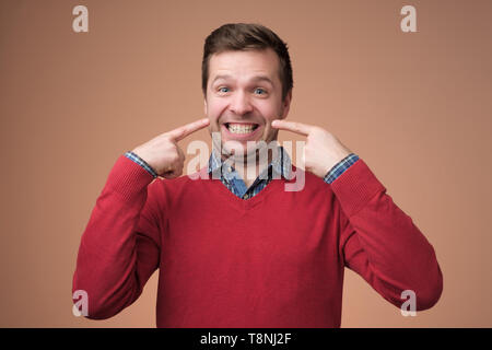 Young european man shows on his teeth. Stock Photo
