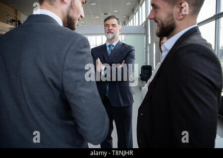 Group of Busy Business People Concept. Business team discussing work in office building hallway. Stock Photo