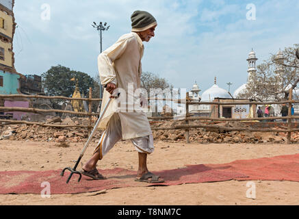 Old man walks through debris in front of the Shri Kashi Vishwanath Temple  during the Lahori Tula urban renewal project in 2019, Varanasi, India Stock Photo