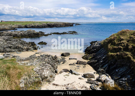 Small sandy beach in a rocky cove between Borthwen and Silver Bay, Rhoscolyn, Isle of Anglesey, Wales, UK, Britain Stock Photo