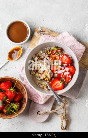 Vegan breakfast. Oatmeal with chia seeds, berries, seeds and caramel in a white bowl. Stock Photo