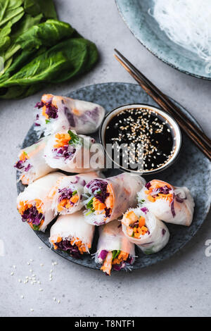Vietnamese rice paper rolls with fresh vegetables and shrimps served with soy sauce. Healthy vegetarian appetizer. Asian cuisine food Stock Photo