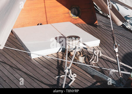 Winches and ropes on wooden boat deck, yacht details Stock Photo