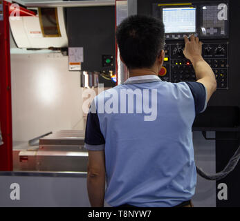 Industrial worker input data to operate cnc milling machine Stock Photo