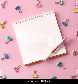 Flat lay picture with blank open notepad and different accessories on colored surface. Feminine workspace Stock Photo