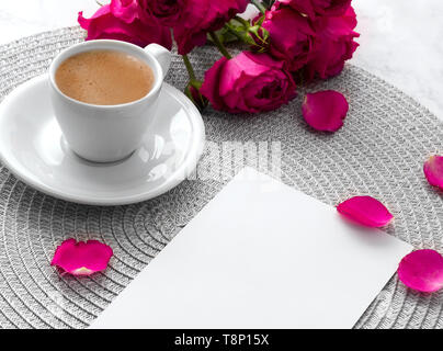 Pink roses with blank greeting card and coffee cup over pink marble background.  Stock Photo