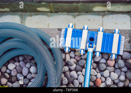 Pool vacuum cleaning flexible hose on the pool Stock Photo