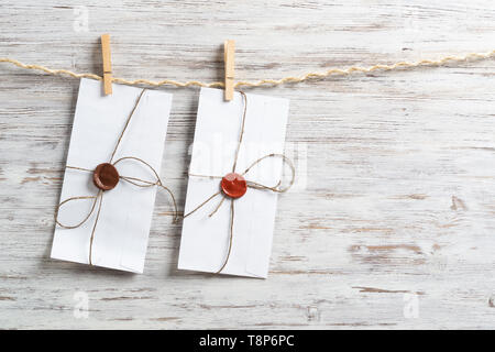 White envelopes hanging on rope Stock Photo