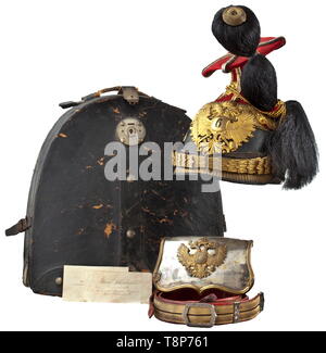 A czapka and a cartridge box of cavalry captain Hans Schönbichler from the Austro-Hungarian Landwehr-Uhlan Regiment No. 6 Czapka with black leather skull, madder red cloth cover, square silver cord. Gilt mounts, leather lined chinscales of interlinked rings, emblem punched with the regiment number '6', black buffalo hair plume, gilt chains on lion head bosses, gold cord indicating the rank with one central and two lateral stripes, white silk lining, inscribed with the owner's name in old handwriting, brown sweatband. Original czapka cover of ligh, Additional-Rights-Clearance-Info-Not-Available Stock Photo