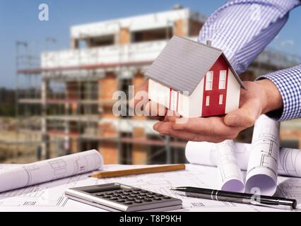 Construction plans with calculator, architectural model and a shell in the background | usage worldwide Stock Photo