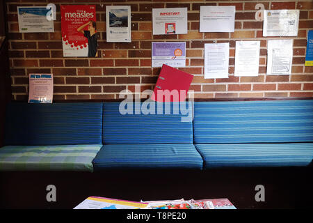 An empty waiting room & advice posters on the way seen in an NHS local doctors surgery waiting room in Warwickshire, UK, On May 14, 2019. Stock Photo
