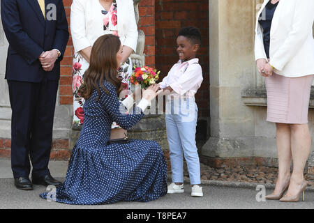 The Duchess of Cambridge is presented with a posy of flowers from young Lawson Bischoff after a visit to Bletchley Park to view a special D-Day exhibition in the newly restored Teleprinter Building. Stock Photo