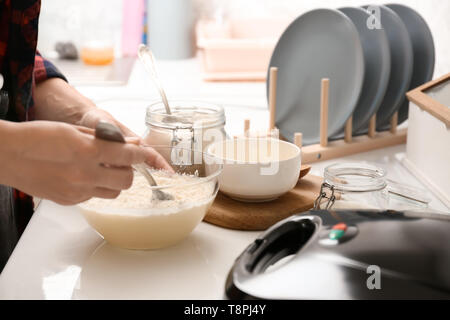 Woman making dough for waffles in kitchen Stock Photo