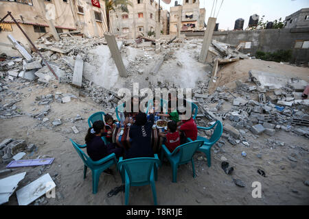 Gaza. 14th May, 2019. Family members of Palestinian Mousa Zorub have their breakfast next to their destroyed house in the southern Gaza Strip city of Rafah, on May 14, 2019. The United Nations Relief and Works Agency for Palestine Refugees in the Near East (UNRWA) said on Monday that more than half of the population in the Gaza Strip may not have enough food by June. Credit: Xinhua/Alamy Live News Stock Photo