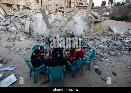 Beijing, China. 15th May, 2019. Family members of Palestinian Mousa Zorub have their breakfast next to their destroyed house in the southern Gaza Strip city of Rafah, on May 14, 2019. The United Nations Relief and Works Agency for Palestine Refugees in the Near East (UNRWA) said on Monday that more than half of the population in the Gaza Strip may not have enough food by June. Credit: Xinhua/Alamy Live News Stock Photo