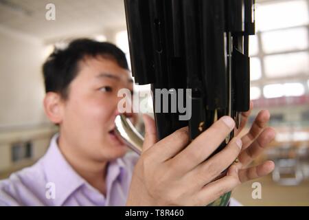 Lanzhou, China's Gansu Province. 13th May, 2019. Player Li Qiang practices playing the Sheng at Lanzhou traditional orchestra in Lanzhou, northwest China's Gansu Province, May 13, 2019. Sheng, a reed-pipe wind instrument, is one of the traditional Chinese musical instruments. It is a polyphonic instrument and enjoys an increasing popularity as a solo instrument. In the modern large Chinese orchestra, it is used for both melody and accompaniment. Credit: Chen Bin/Xinhua/Alamy Live News Stock Photo