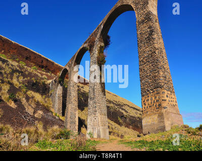 High viaduct, formerly used as aqueduct spans a Barranco on tenerife in Puerto de la Cruz. impressionistic partial view, the picture is divided diagon Stock Photo