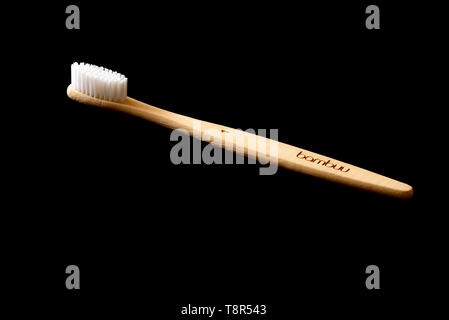 Bamboo tooth brush on a black background. Eco friendly hygiene product. Stock Photo