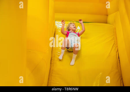 Little girl ride from an inflatable slide Stock Photo