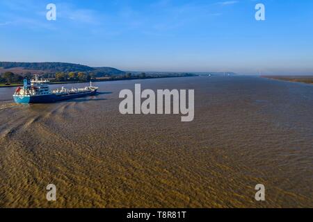 France, Seine Maritime, Natural Reserve of the Seine estuary, cargo ship going down the Seine from Rouen, the Normandie bridge in the background (aerial view) Stock Photo