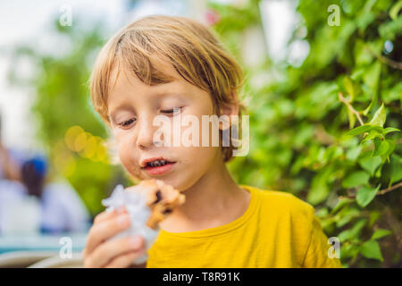 Sweet little caucasian boy, eating pancakes and drinking orange juice Stock Photo