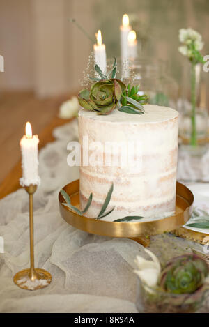 Elegant white wedding cake with flowers and succulents in boho style. Rustic Wedding Cake Stock Photo