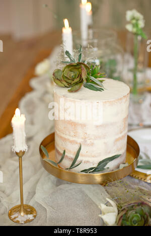 Elegant white wedding cake with flowers and succulents in boho style. Rustic Wedding Cake Stock Photo