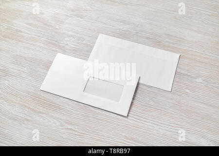 Photo of two blank paper envelopes on light wooden background. Back and front. Stock Photo