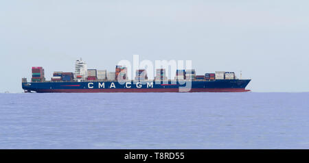 Genoa, Italy   April  10, 2019:  Big Container  cargo ship CMA CGM NABUCCO leaving port  after loading unloading operations - side view Stock Photo