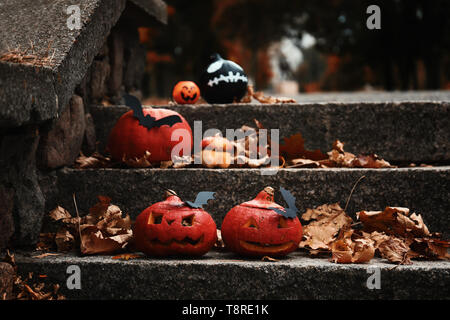 Halloween pumpkins with creative decorations on stairs outdoors Stock Photo