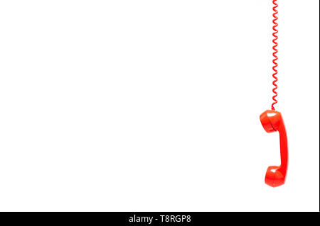 Red old telephone receiver isolated on white background with texting space, phone hanging, waiting for phone call, retro telephone. Stock Photo