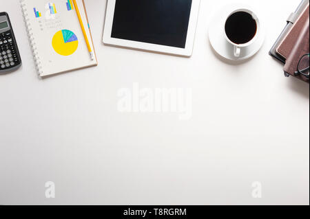Top view of tablet, notebook, a cup of coffee on white background, planning personal budget, business and financial concept. Stock Photo