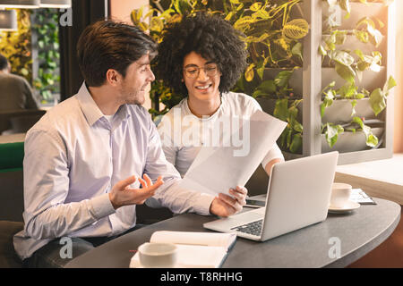 Two handsome businessmen in cafe discussing important project Stock Photo