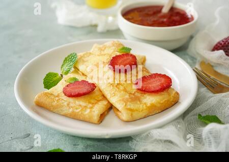 Baked Sweet Ricotta Crepes / Homemade thin breakfast pancakes with cottage cheese stuffing , selective focus Stock Photo