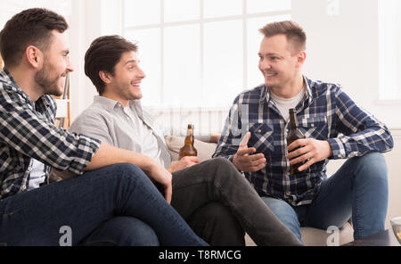 Happy Mates Drinking Beer And Talking At Home Stock Photo