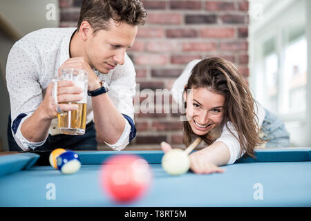 Couple playing snooker game and drinking beer. Stock Photo