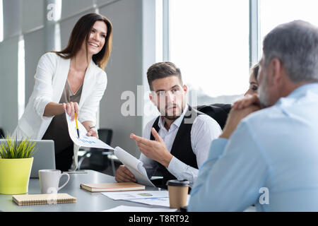 Businesswoman Leads Meeting Around Table. Discussion Talking Sharing Ideas Concept. Stock Photo