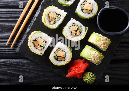 Green japanese roll with avocado, tamago omelette, sesame and cucumber closeup on a plate on the table. horizontal top view from above Stock Photo