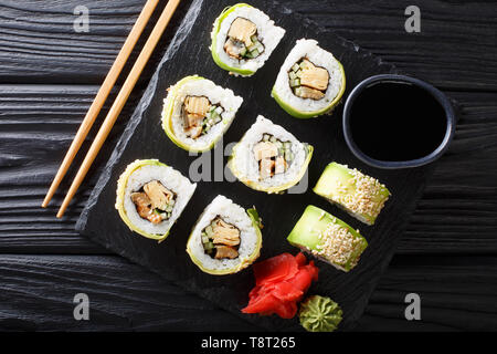 set of Japanese rolls of green dragon with avocado, omelet, sesame and cucumber closeup on a plate on the table. horizontal top view from above Stock Photo