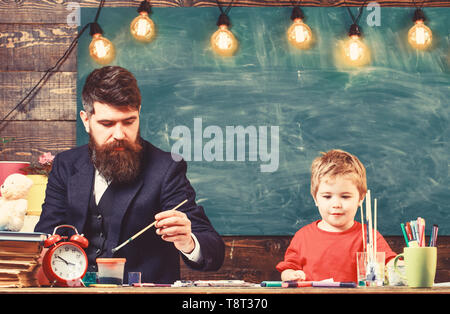 Home education concept. Father and son painting together. Developing kids creativity. Stock Photo