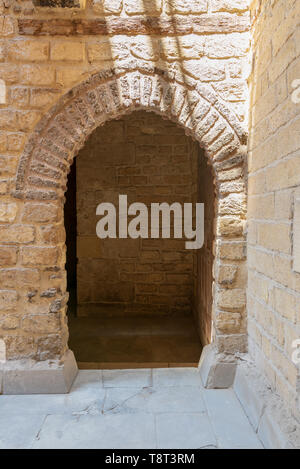 Vaulted open wooden grunge door in bricks stone wall, Old Cairo, Egypt Stock Photo