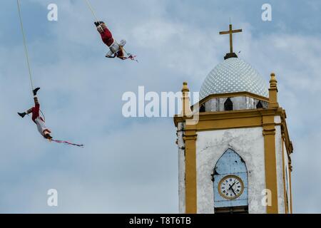 Voladores performs in front of the Church of the Assumption in Papantla,  Veracruz, Mexico. The Danza de los Voladores is a indigenous Totonac  ceremony involving five participants who climb a thirty-meter pole. Four of  these tie ropes around their waists