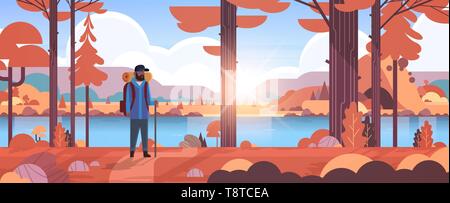male tourist hiker with backpack african american man traveler holding stick standing in forest hiking concept autumn landscape nature river mountains Stock Vector