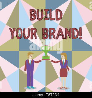 Word writing text Build Your Brand. Business photo showcasing creates or improves customers knowledge and opinions of product Man and Woman in Busines Stock Photo