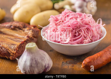 Sour cabbage with smoked ribs sausages potatoes and garlic Stock Photo